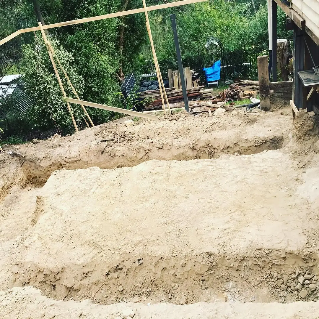 Deep cut at Healesville stepped back in benches through pale subsoil, with the existing house and timber propping above