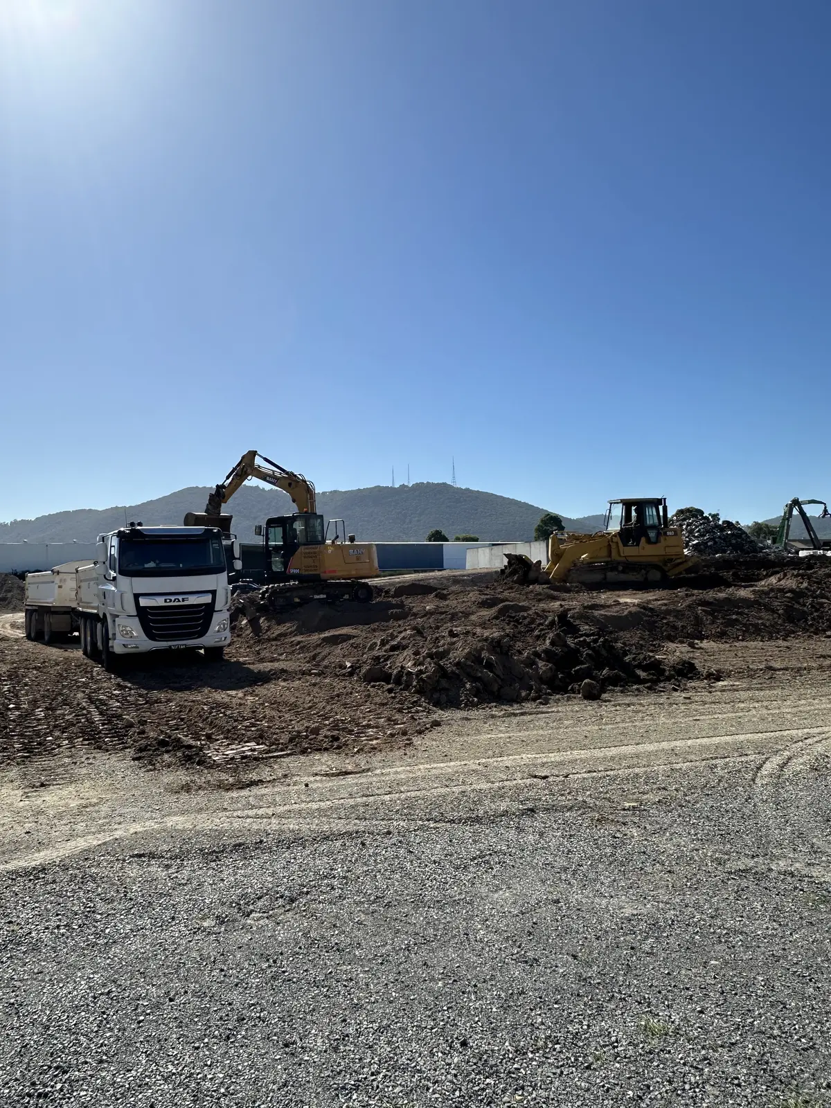 Freshly formed gravel driveway with truck and excavators, Yarra Valley hills backdrop
