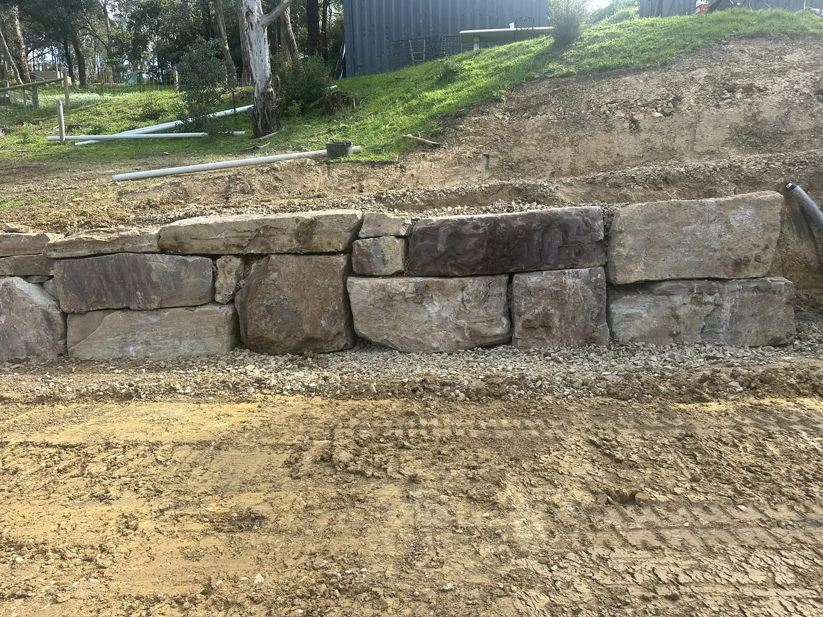 Entire Excavations rockwall retaining wall built into a sloped site