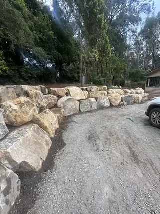 Rockwall bordering a gravel driveway