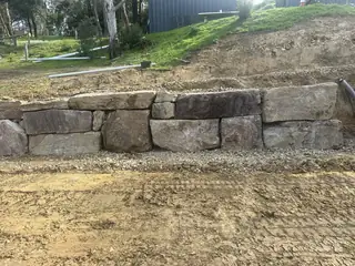 Entire Excavations rockwall retaining wall built into a sloped site